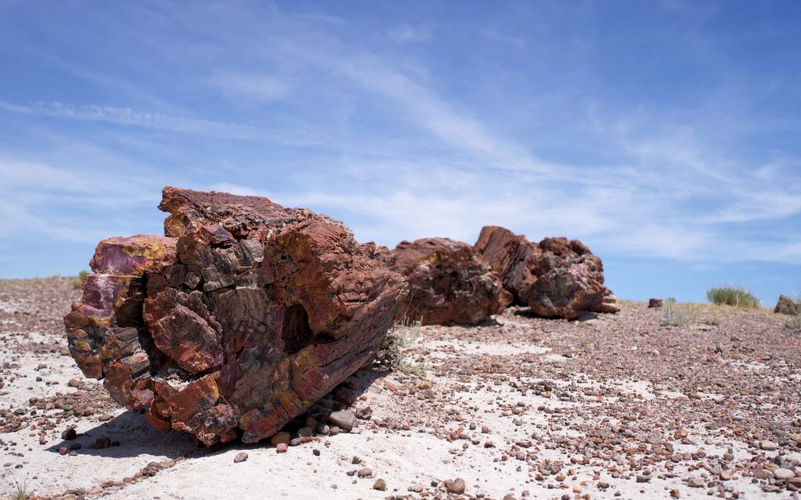 A sunlit rocky landscape beneath a clear blue sky.